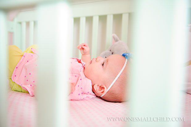 Sweet baby Lyla in her aqua crib | See the entire nursery at One Small Child: www.onesmallchild.com