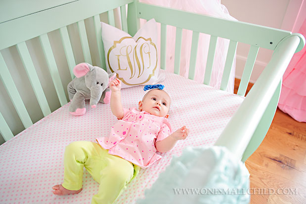 Sweet baby Lyla in her pink and aqua dream crib | See the entire nursery at One Small Child: www.onesmallchild.com